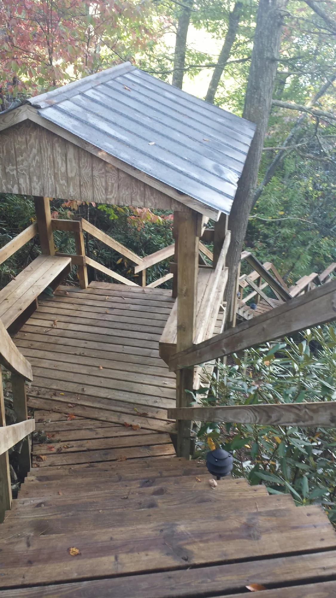 Metal roofed shelter over wooden steps on a wooded walkway — Skylight Repair & Installation work by our crew in Monroeville