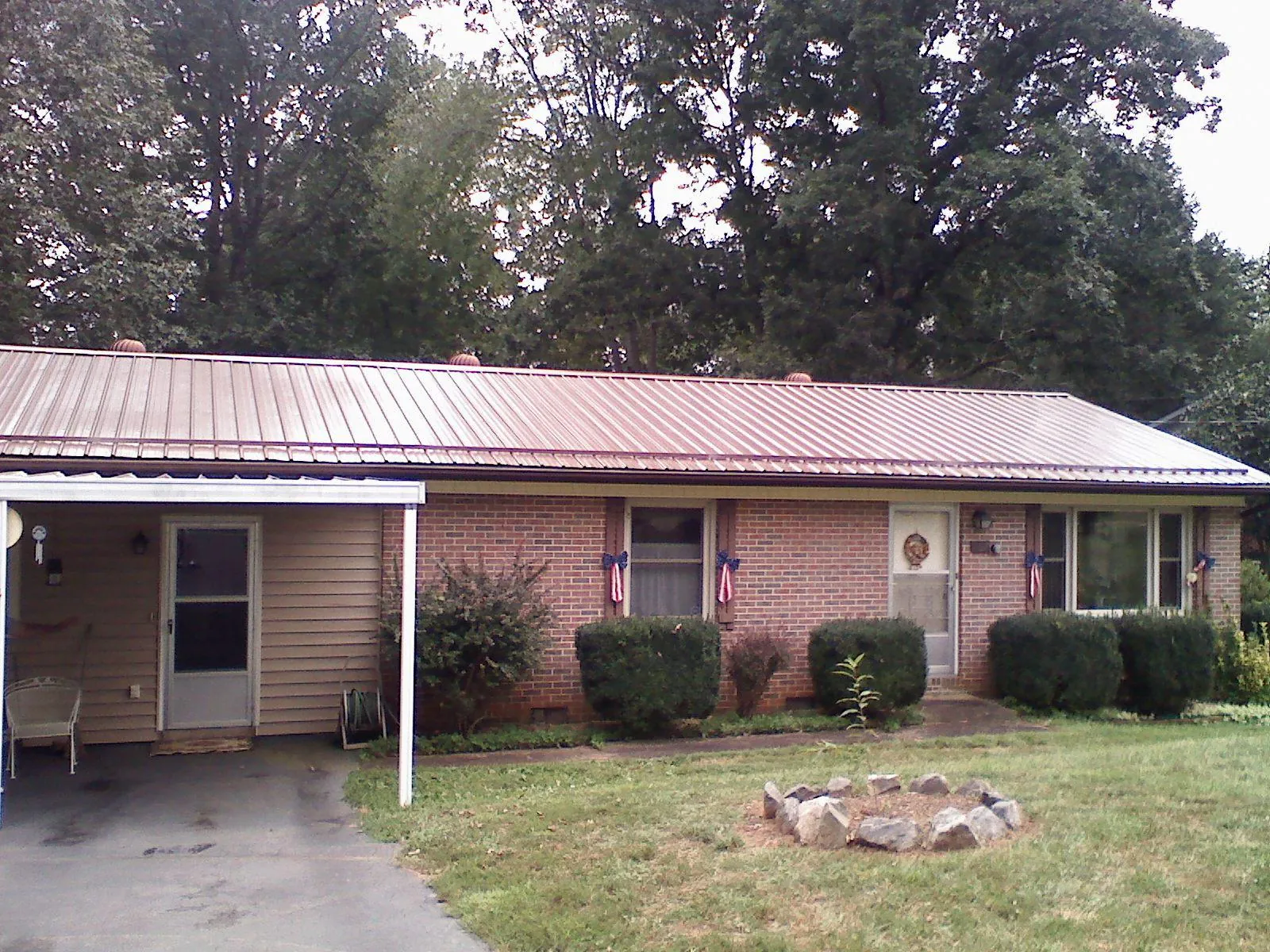 Bronze metal roof and carport on a brick ranch home — Roof Repair work by our crew in Monroeville